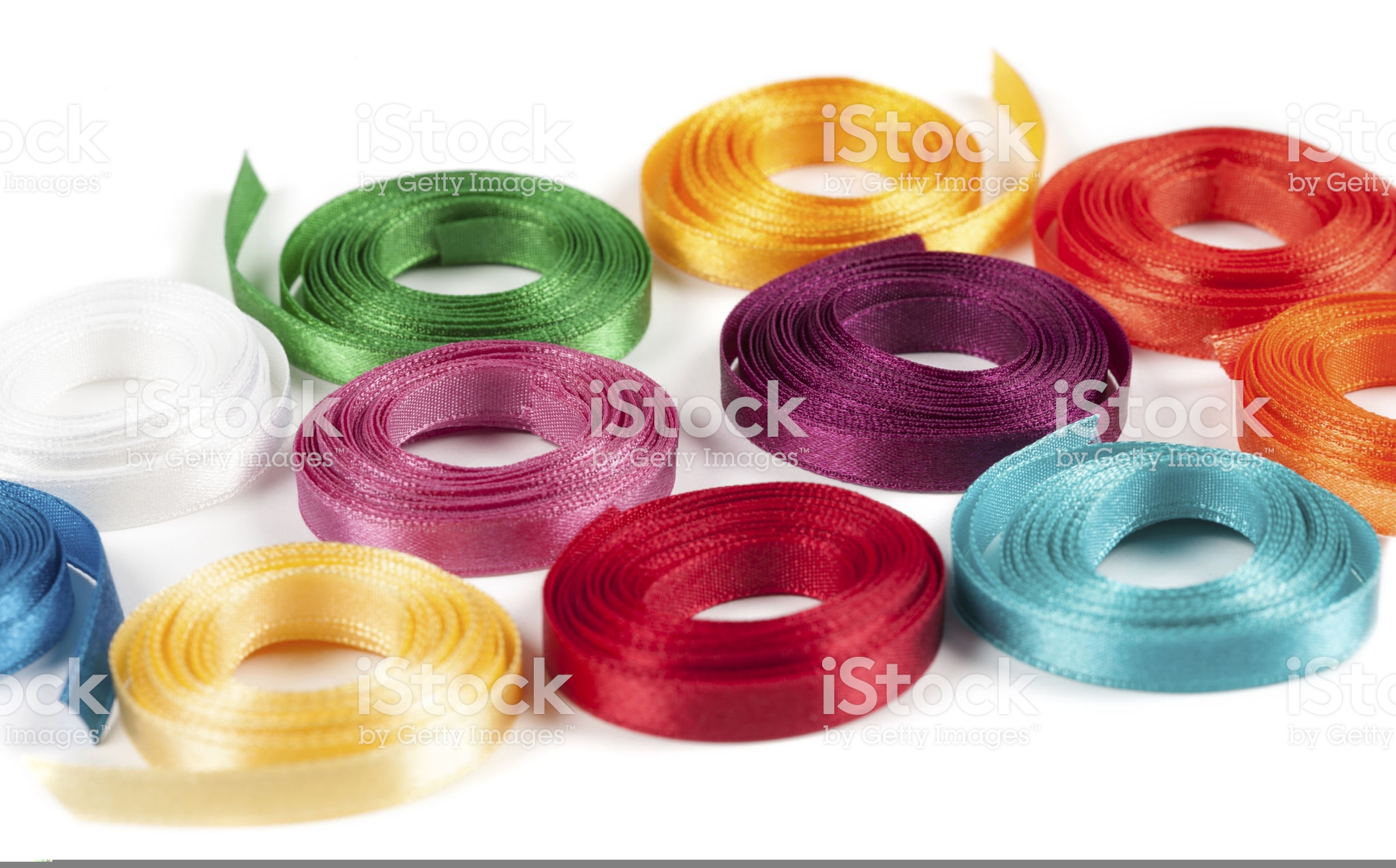 Coiled spools of colorful ribbons on a white background | Jascotina Inc.
